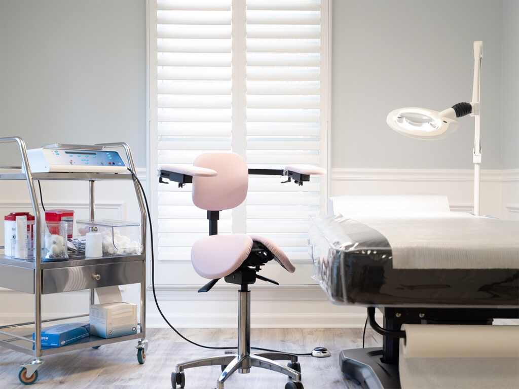 Electrolysis treatment room at Emmie's Electrolysis featuring treatment bed, magnifying lamp, and electrolysis equipment.